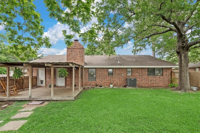 227 Oak Hollow St, Conroe, TX 77301 - rear view of house featuring a chimney, a wooden deck, brick siding, fence, and a yard