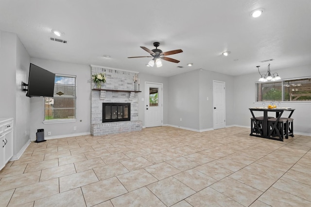 227 Oak Hollow St, Conroe, TX 77301 - unfurnished living room featuring visible vents, ceiling fan with notable chandelier, a healthy amount of sunlight, and a fireplace