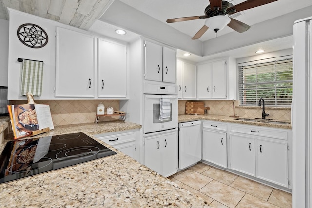 227 Oak Hollow St, Conroe, TX 77301 - kitchen with ceiling fan, a sink, light tile patterned floors, white appliances, and white cabinetry