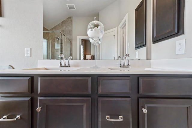 full bath featuring double vanity, a shower stall, and a sink