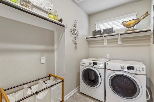 laundry room with laundry area, washer and clothes dryer, baseboards, and light tile patterned flooring