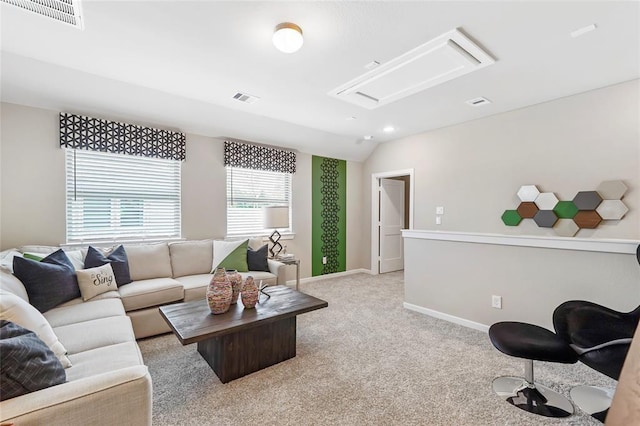 living area with vaulted ceiling, light colored carpet, attic access, and visible vents