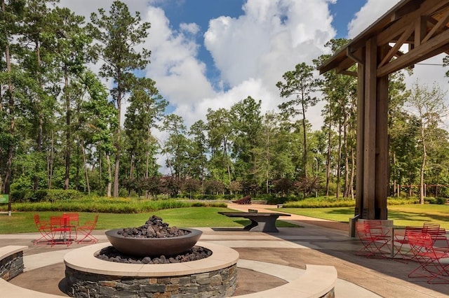 view of property's community with a yard and a fire pit