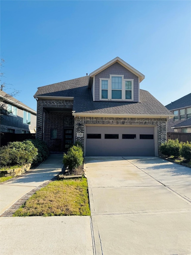 view of front of house with brick siding, roof with shingles, and concrete driveway
