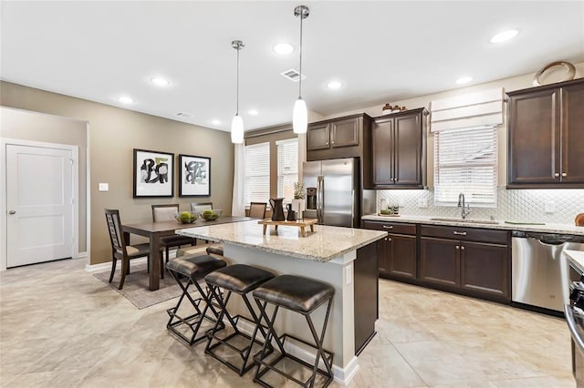 kitchen featuring stainless steel appliances, a sink, and dark brown cabinets