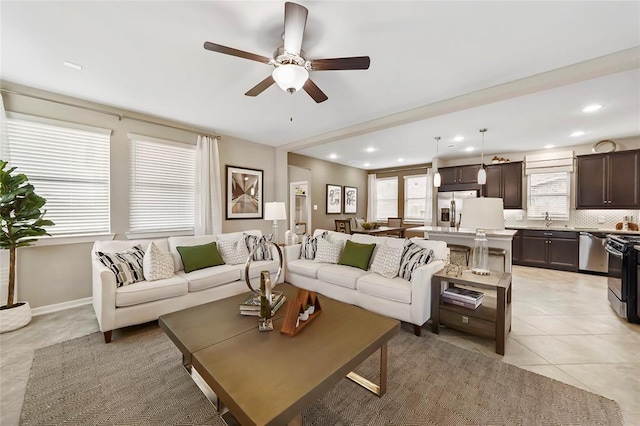 living area with light tile patterned floors, baseboards, a ceiling fan, and recessed lighting