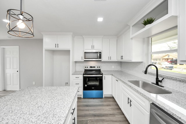 kitchen featuring white cabinets, dark wood-style flooring, a sink, stainless steel appliances, and decorative backsplash