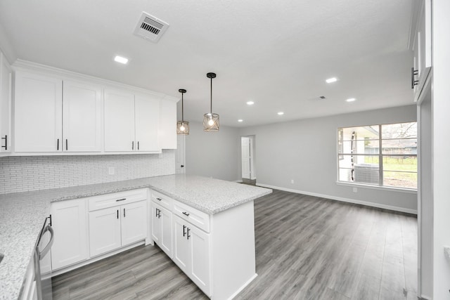 kitchen with visible vents, tasteful backsplash, a peninsula, open floor plan, and white cabinetry