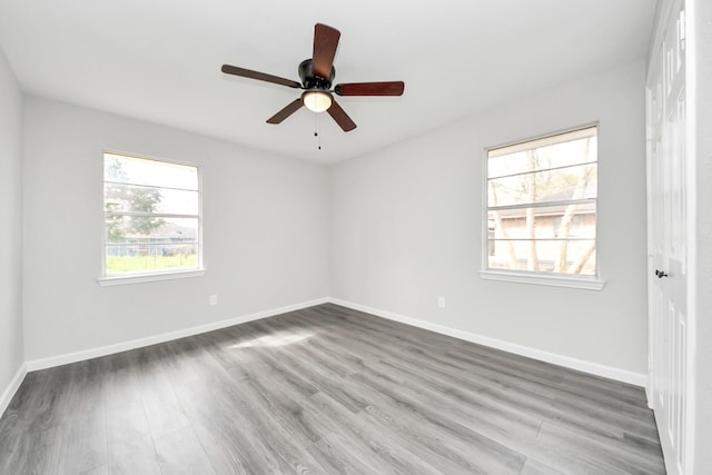 spare room featuring baseboards, ceiling fan, and wood finished floors