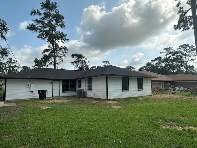 back of property featuring a lawn and cooling unit