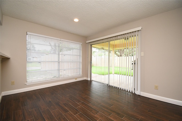 spare room featuring recessed lighting, baseboards, a textured ceiling, and dark wood-type flooring