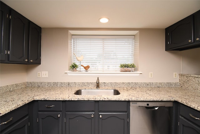 kitchen with stainless steel dishwasher, recessed lighting, a sink, and light countertops