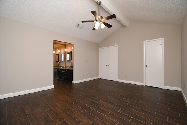 interior space featuring dark wood-style flooring, ceiling fan, lofted ceiling with beams, baseboards, and visible vents