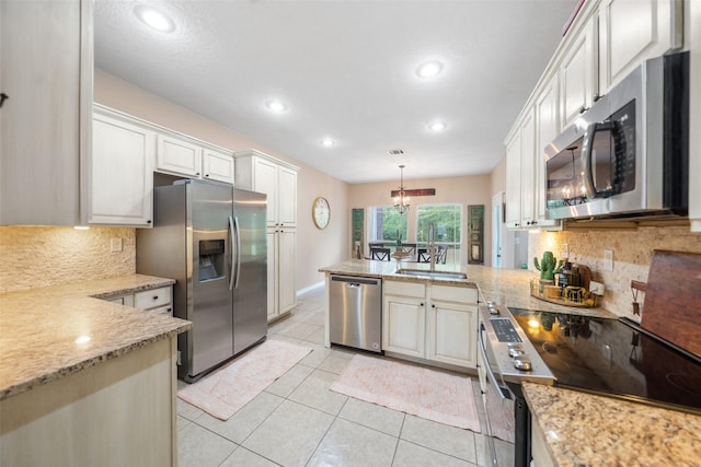 kitchen with recessed lighting, stainless steel appliances, a peninsula, and a sink