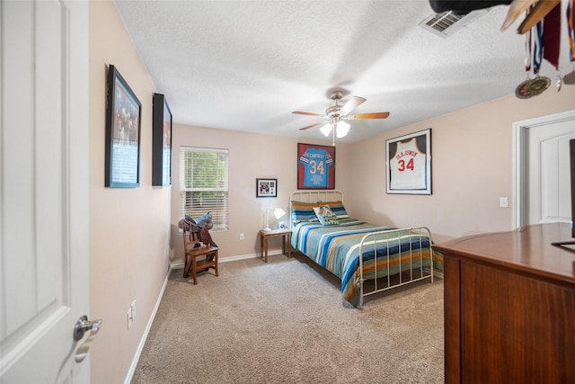 bedroom with a ceiling fan, a textured ceiling, visible vents, light colored carpet, and baseboards