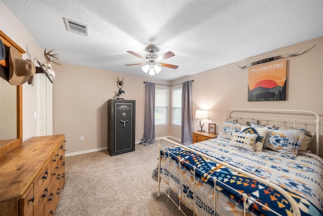 bedroom with a textured ceiling, carpet, a ceiling fan, baseboards, and visible vents