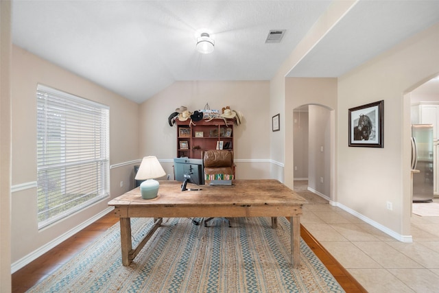 home office with arched walkways, a wealth of natural light, baseboards, and visible vents