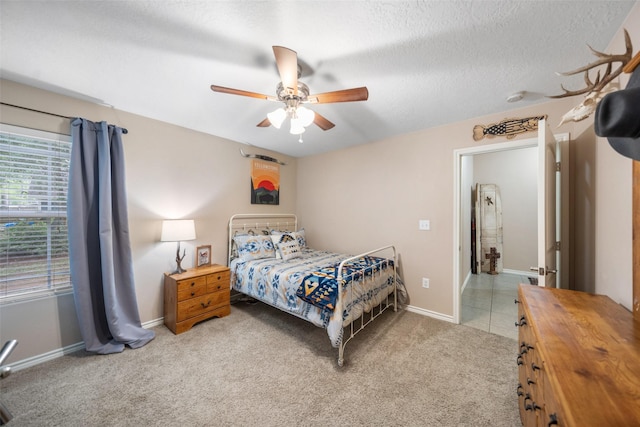 carpeted bedroom with ceiling fan and baseboards