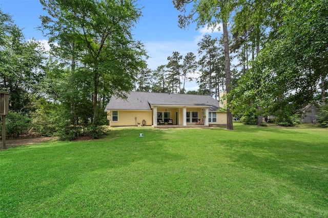 back of property featuring a chimney, a yard, and a patio area