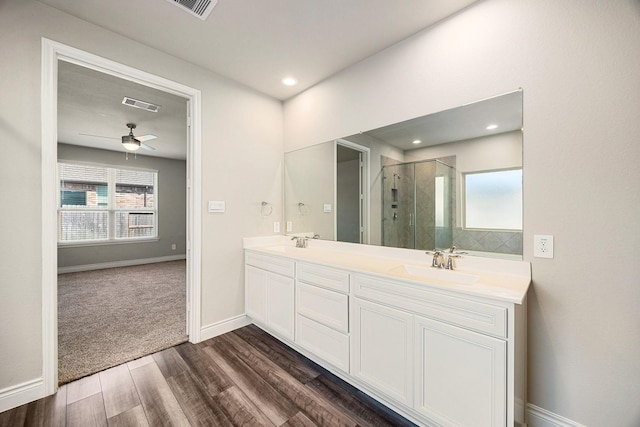 31214 Gullwing Manor Dr, Tomball, TX 77375 - bathroom featuring double vanity, visible vents, a shower stall, wood finished floors, and a sink