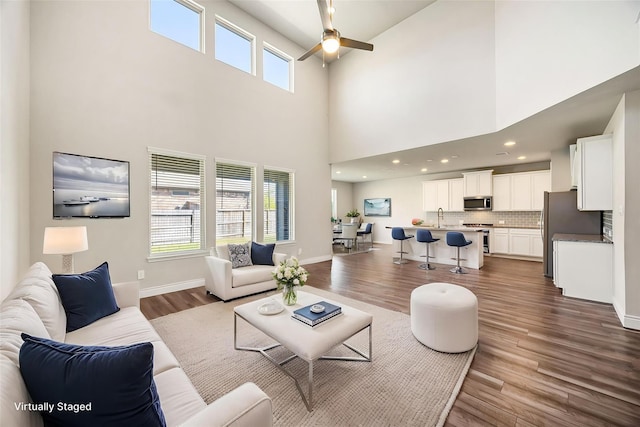 31214 Gullwing Manor Dr, Tomball, TX 77375 - living room with dark wood-type flooring, a ceiling fan, baseboards, and plenty of natural light