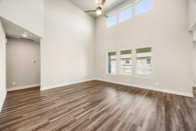 31214 Gullwing Manor Dr, Tomball, TX 77375 - unfurnished room featuring ceiling fan, visible vents, a towering ceiling, wood finished floors, and baseboards