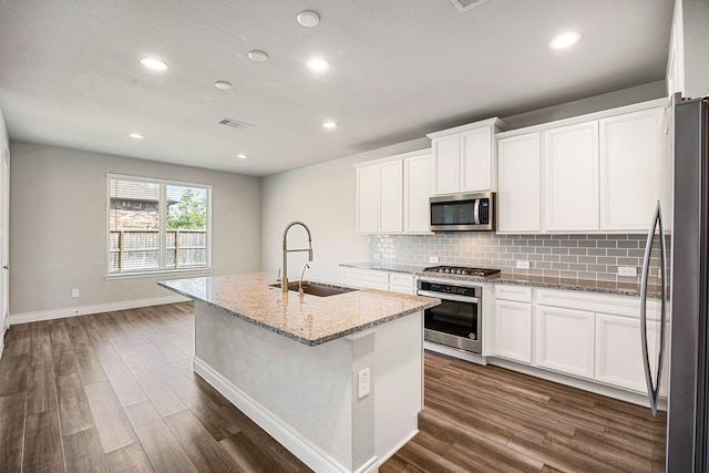 31214 Gullwing Manor Dr, Tomball, TX 77375 - kitchen featuring dark wood finished floors, appliances with stainless steel finishes, a sink, and tasteful backsplash