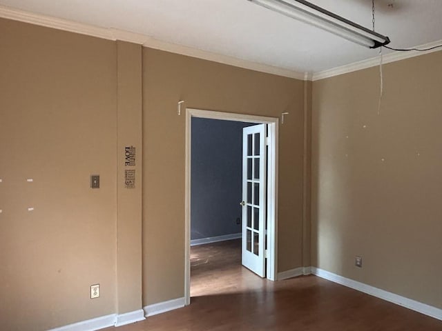 empty room with baseboards, ornamental molding, and wood finished floors