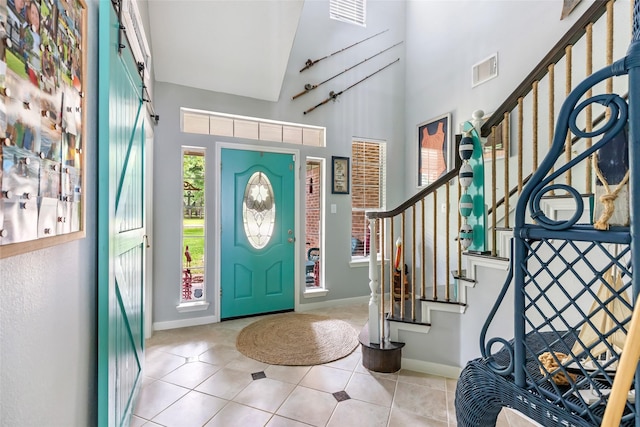 foyer entrance featuring stairs, high vaulted ceiling, visible vents, and tile patterned flooring