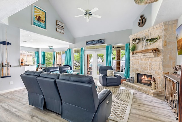 living area featuring a healthy amount of sunlight, high vaulted ceiling, and wood finished floors