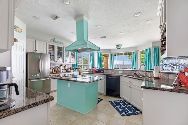 kitchen featuring a sink, dark stone countertops, island exhaust hood, glass insert cabinets, and black appliances