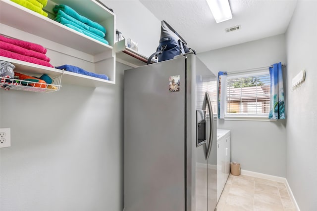 clothes washing area featuring laundry area, visible vents, light tile patterned floors, baseboards, and separate washer and dryer