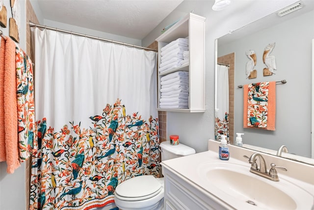 bathroom with toilet, a shower with curtain, visible vents, and vanity