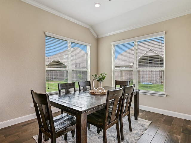 dining space featuring baseboards, ornamental molding, wood finished floors, and lofted ceiling