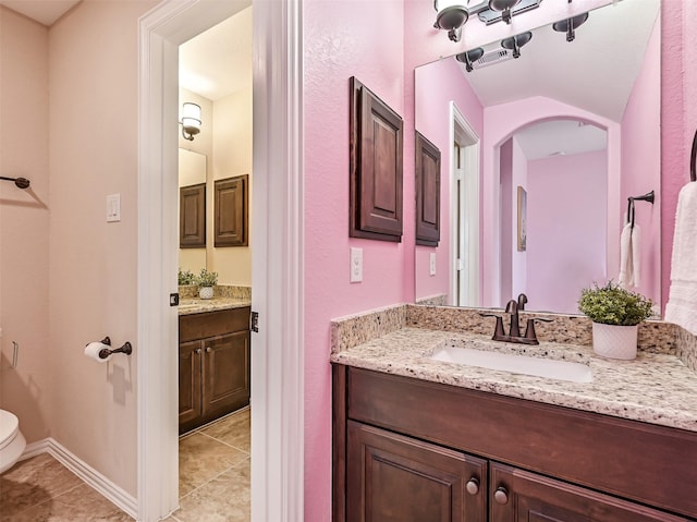 bathroom featuring tile patterned flooring, toilet, and vanity