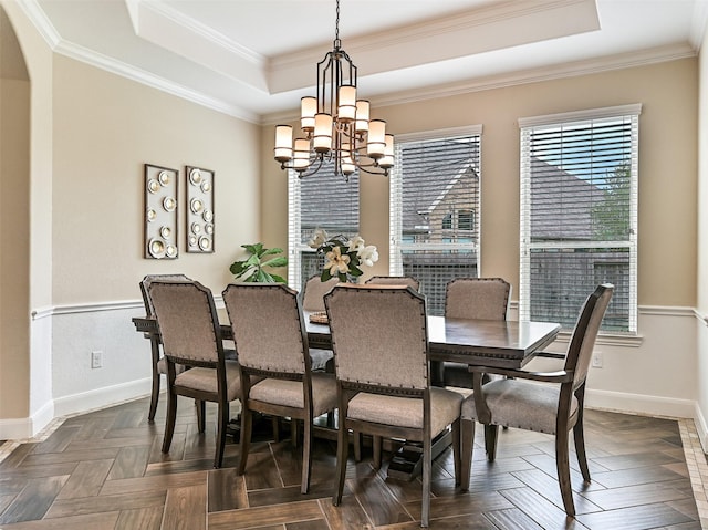 dining space featuring crown molding, baseboards, a chandelier, and a raised ceiling