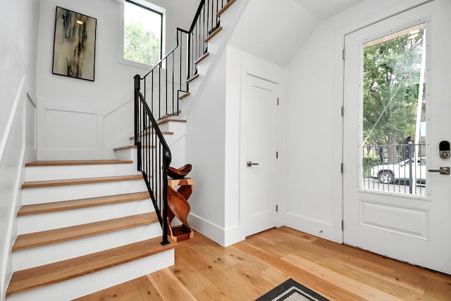 2303 Yupon St, Houston, TX 77006 - entrance foyer featuring baseboards, stairs, light wood-style flooring, and a wealth of natural light
