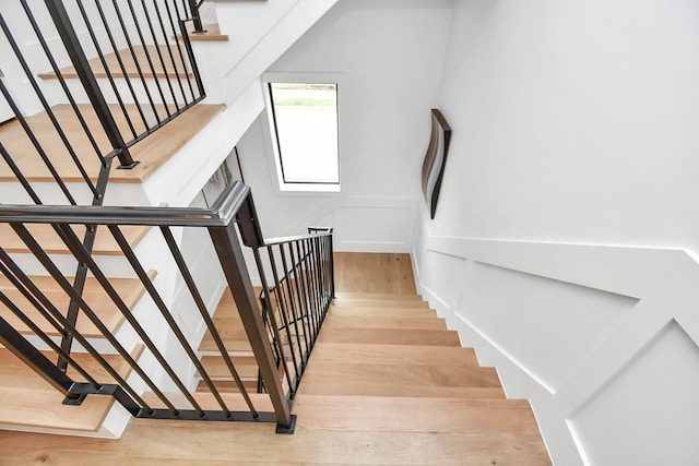2303 Yupon St, Houston, TX 77006 - stairs featuring a decorative wall, wood finished floors, and a wainscoted wall