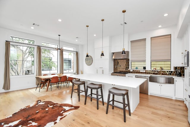 2303 Yupon St, Houston, TX 77006 - kitchen with visible vents, a kitchen island, tasteful backsplash, a sink, and stainless steel appliances