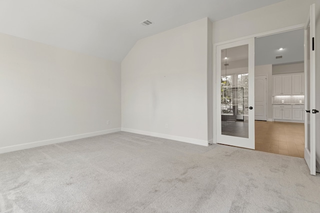 21873 Otter Point Ln, Porter, TX 77365 - empty room with baseboards, visible vents, light carpet, and vaulted ceiling