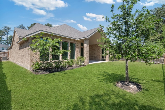 21873 Otter Point Ln, Porter, TX 77365 - exterior space featuring fence, roof with shingles, central air condition unit, brick siding, and a lawn