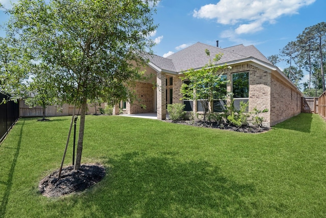 21873 Otter Point Ln, Porter, TX 77365 - back of property with brick siding, a fenced backyard, a lawn, and roof with shingles