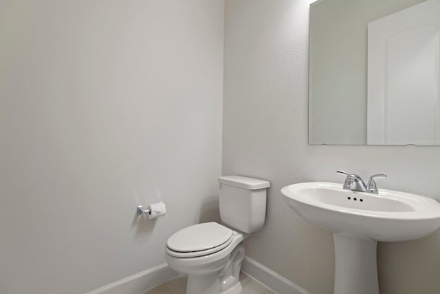 21873 Otter Point Ln, Porter, TX 77365 - bathroom featuring toilet, baseboards, a sink, and tile patterned floors