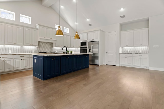 21873 Otter Point Ln, Porter, TX 77365 - kitchen with visible vents, built in appliances, high vaulted ceiling, white cabinets, and tasteful backsplash