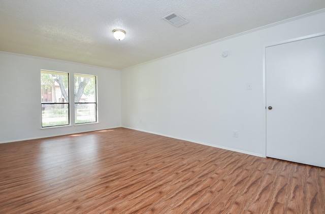 2814 River Birch Dr, Sugar Land, TX 77479 - empty room with a textured ceiling, visible vents, light wood-type flooring, baseboards, and ornamental molding