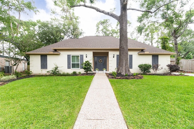 ranch-style house with a front lawn, roof with shingles, fence, and cooling unit