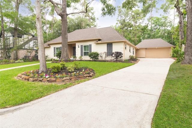 ranch-style house featuring an outbuilding, brick siding, a front lawn, concrete driveway, and a shingled roof