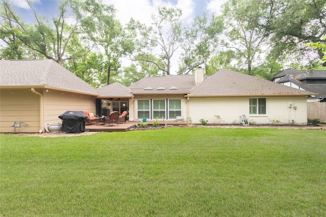 rear view of house featuring ceiling fan, a chimney, a shingled roof, a patio area, and a yard