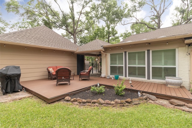 wooden terrace featuring area for grilling and a yard