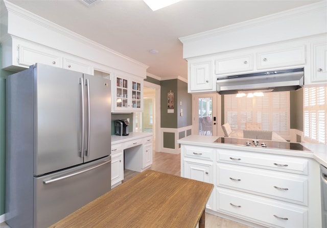kitchen with freestanding refrigerator, white cabinetry, crown molding, and under cabinet range hood